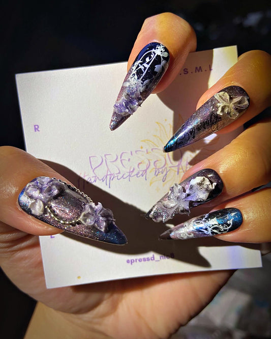 Midnight Veil press-on nails: violet and navy cat-eye stiletto nails with silver florals and lilac 3D petals