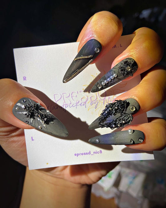 Obsidian press-on nails: matte charcoal stiletto nails with black 3D texture, chain and crystals
