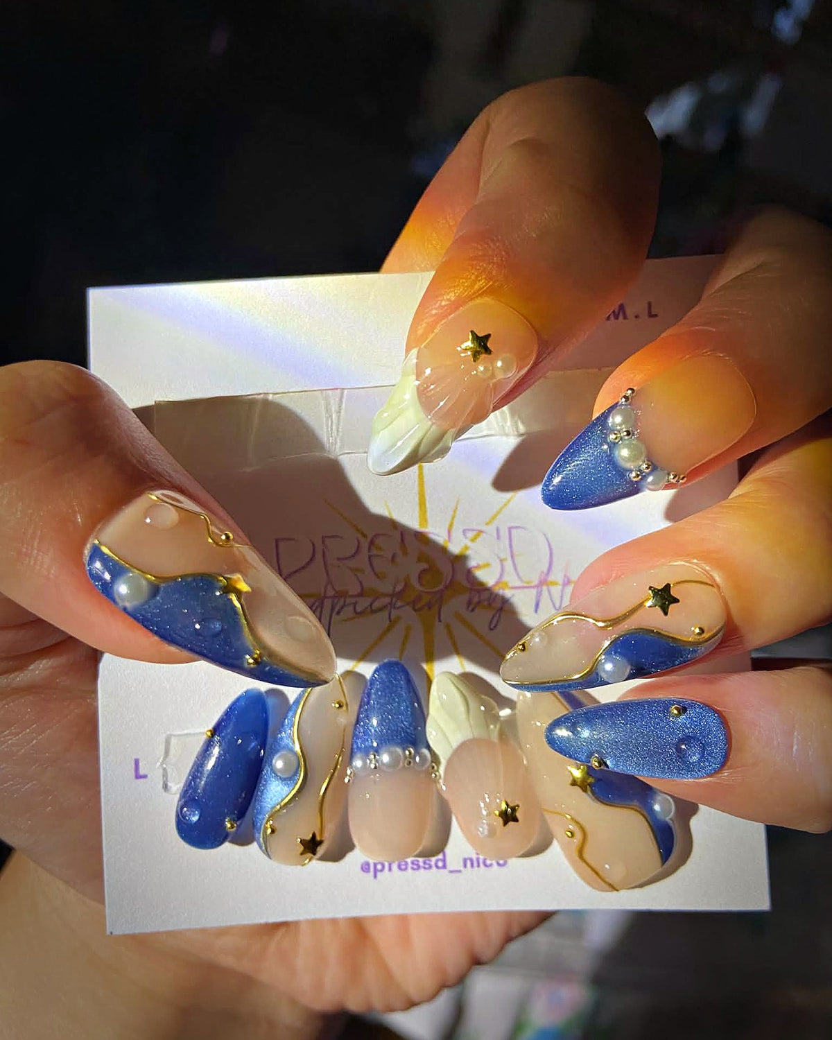 Starry Denim press-on nails: blue cat-eye and nude almond nails with gold stars and pearls
